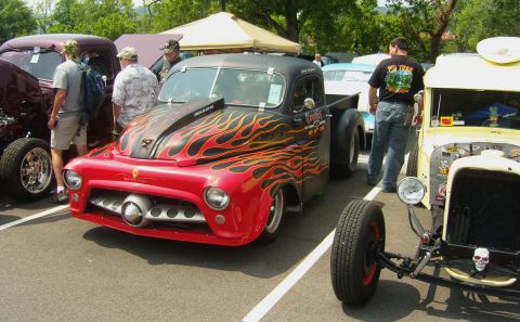 2007 Ford Mustang - A custom pickup truck with flame graphics is displayed at an outdoor event.