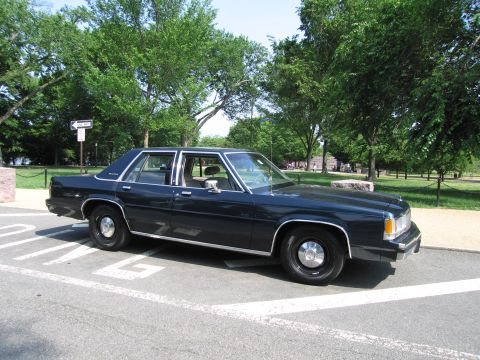 1991 Ford Crown Victoria - Dark blue 1991 Ford Crown Victoria parked on pavement near a park.