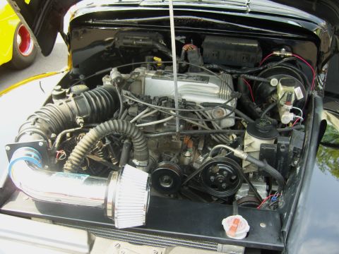 2007 Ford Mustang - The engine bay of a vehicle, showing various components and an aftermarket air intake system.