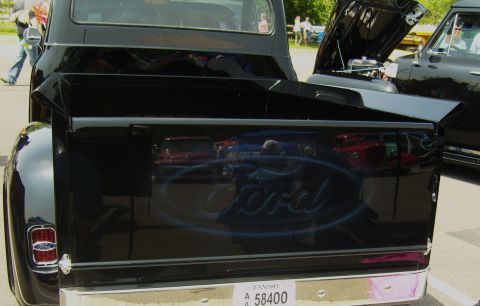 2007 Ford Mustang - A black 1950s Ford pickup truck is shown from the rear, with a custom airbrushed Ford logo on the tailgate.