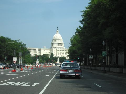 1991 Ford Crown Victoria - A 1991 Ford Crown Victoria police car drives past the US Capitol building on a sunny day.