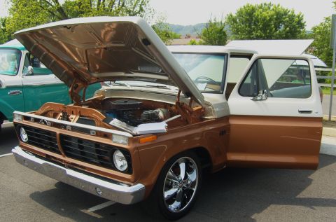 2007 Ford Mustang - Two-tone Ford F-Series truck on display, hood and door open, with another truck nearby.