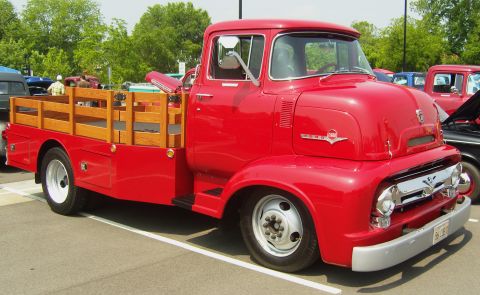 2007 Ford Mustang - A vintage red flatbed truck is parked at an outdoor event.