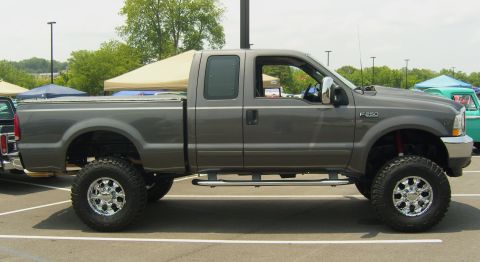 2007 Ford Mustang - A lifted Ford F-250 pickup truck is parked at an outdoor event.