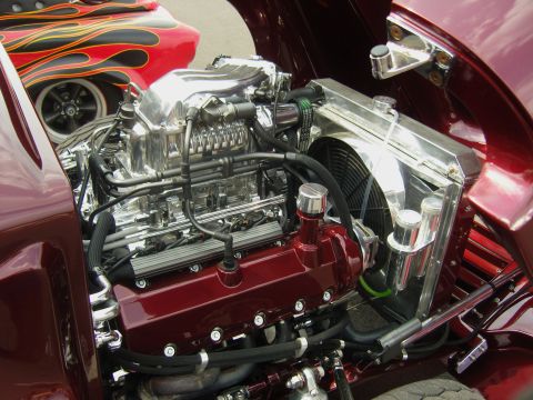 2007 Ford Mustang - Custom engine bay features a polished supercharger and vibrant red valve covers, with flame graphics visible on the fender.