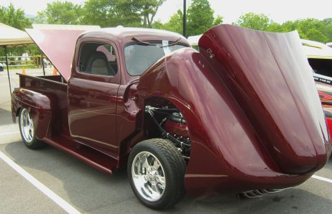 2007 Ford Mustang - A custom maroon pickup truck is displayed with its hood and trunk open, revealing its engine and interior.