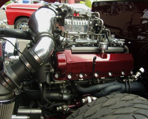 2007 Ford Mustang - Close-up of a custom supercharged engine with polished components and red valve covers.