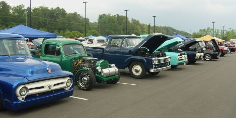 2007 Ford Mustang - A row of vintage pickup trucks are parked at an outdoor event, with their hoods open.