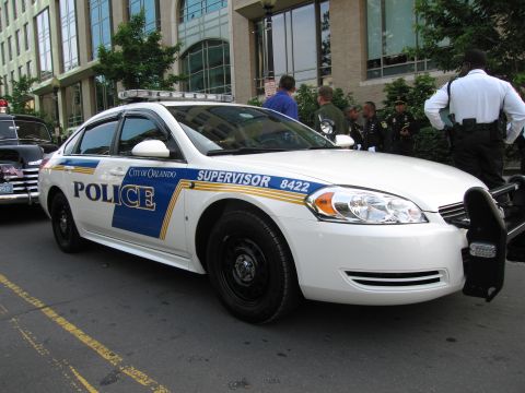 1991 Ford Crown Victoria - Orlando Police supervisor vehicle parked on street, with another older vehicle nearby.