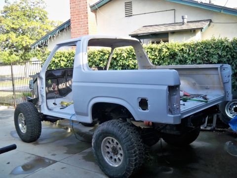1985 Ford Bronco - This Ford Bronco body is being prepped for paint, with doors removed and large tires installed.