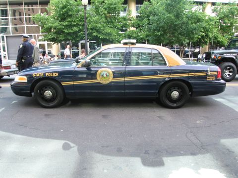 1991 Ford Crown Victoria - Side view of a 1991 Ford Crown Victoria police car with 'STATE POLICE' text on the door.
