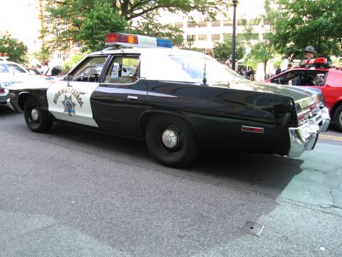 1991 Ford Crown Victoria - A vintage police car is parked on the street, with other vehicles nearby.