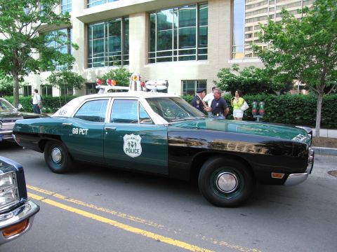 1991 Ford Crown Victoria - A vintage police car, marked '68 PCT' and 'POLICE', is parked on a street.