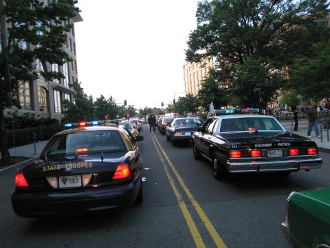 1991 Ford Crown Victoria - Multiple police vehicles, including a 1991 Ford Crown Victoria, are stopped on a city street.