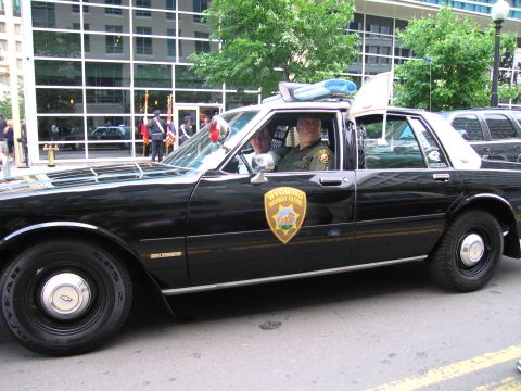 1991 Ford Crown Victoria - A 1991 Ford Crown Victoria police car, marked with the Wyoming Highway Patrol insignia, is seen from the side.