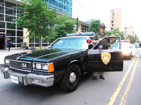 1991 Ford Crown Victoria - Wyoming Highway Patrol car with officer. Another patrol vehicle is seen in the background.