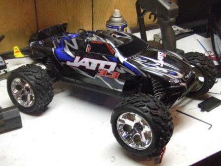 1996 Ford Bronco - Remote control monster truck with "JATO 3.3" graphics sits on a workbench.