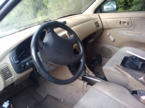 1998 Subaru Legacy - The interior of an older vehicle shows the driver's side dashboard, steering wheel, and part of the passenger area.