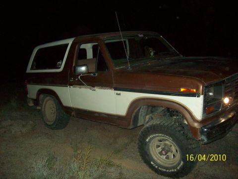 1985 Ford Bronco - This two-tone brown and white Ford Bronco appears to be a 1985 model, seen here parked off-road in the dark.