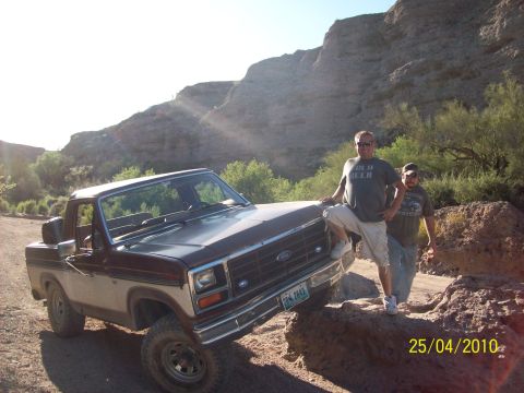 1985 Ford Bronco - A Ford F-Series truck is parked on rocks with two men standing nearby.