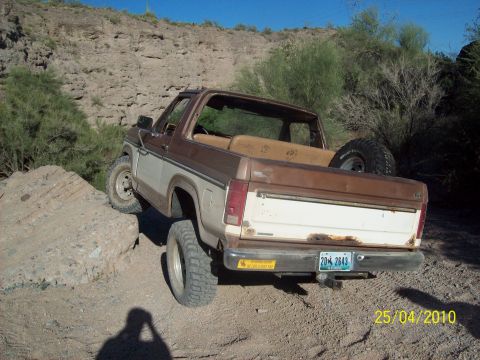 1985 Ford Bronco - This 1985 Ford Bronco is navigating a rocky off-road path under a clear blue sky.