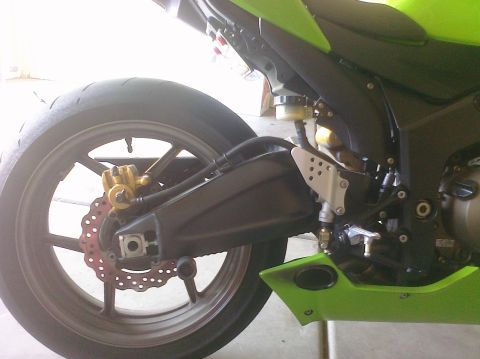 2005 Kawasaki Ninja R - Close-up of a motorcycle's rear wheel and swingarm assembly, with green bodywork.