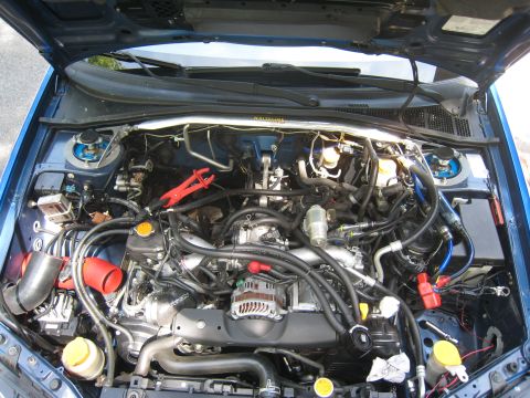 2007 Subaru Impreza - The engine bay of a blue car, showing a complex arrangement of mechanical parts and wiring.