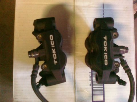 2005 Kawasaki Ninja R - Two black Tokico brake calipers are shown, likely for a motorcycle, with visible hoses and mounting hardware.