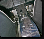 1986 Ford Bronco - Close-up of a car's interior center console and gear shifter, showing carbon fiber accents.