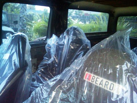 1986 Ford Bronco - Seats covered in plastic, one with a BEARD label, are visible inside the vehicle.