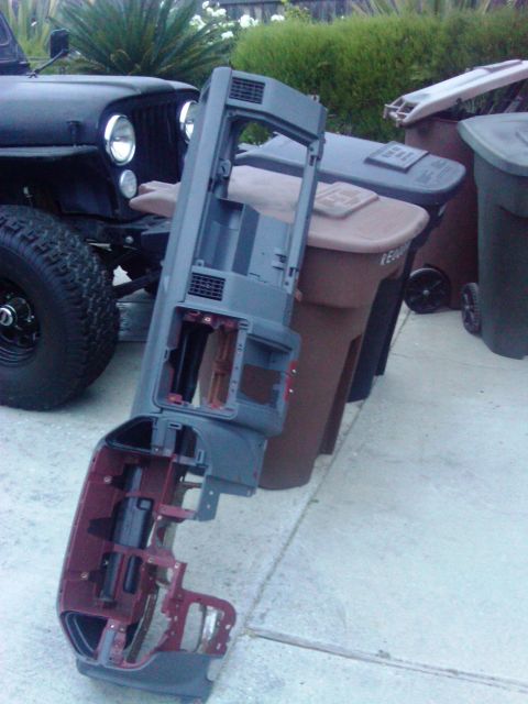 1986 Ford Bronco - Dashboard assembly removed from a vehicle, with a Jeep in the background.