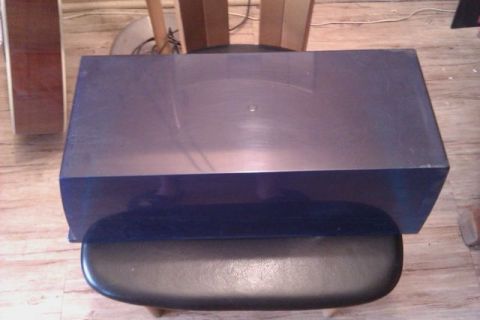 1991 Ford Crown Victoria - Blue electronic component on a stool, with speakers and wooden floor visible.
