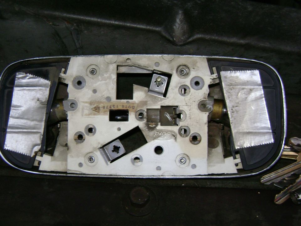 Back of a dome light assembly with Ford logo visible. Some text and part numbers are present