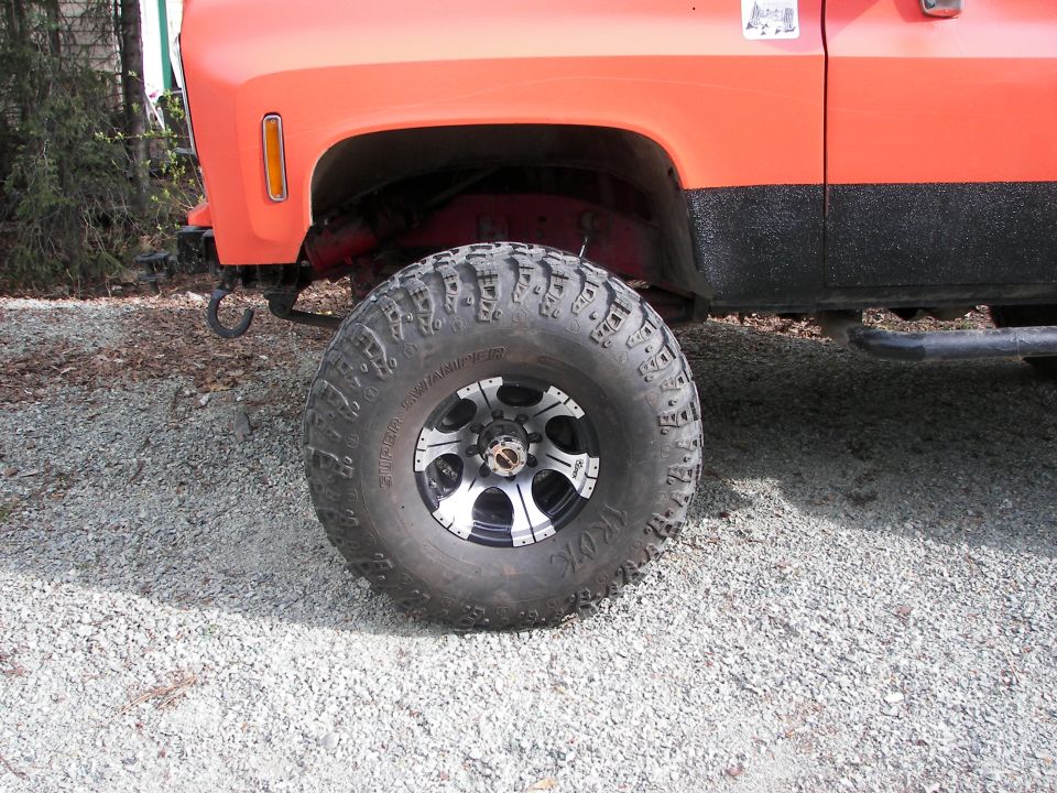 Orange lifted truck with large off-road tires and black trim