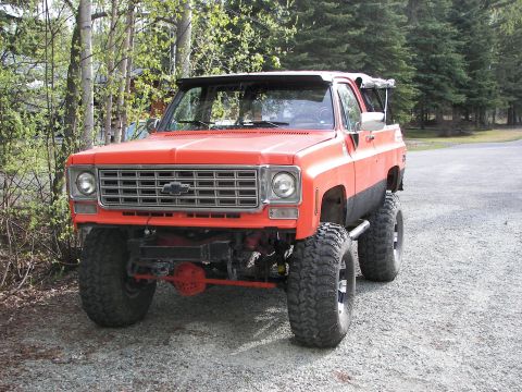 1990 Chevrolet Suburban - This lifted SUV features a distinctive grille and aggressive tires, suggesting an earlier model year than claimed.