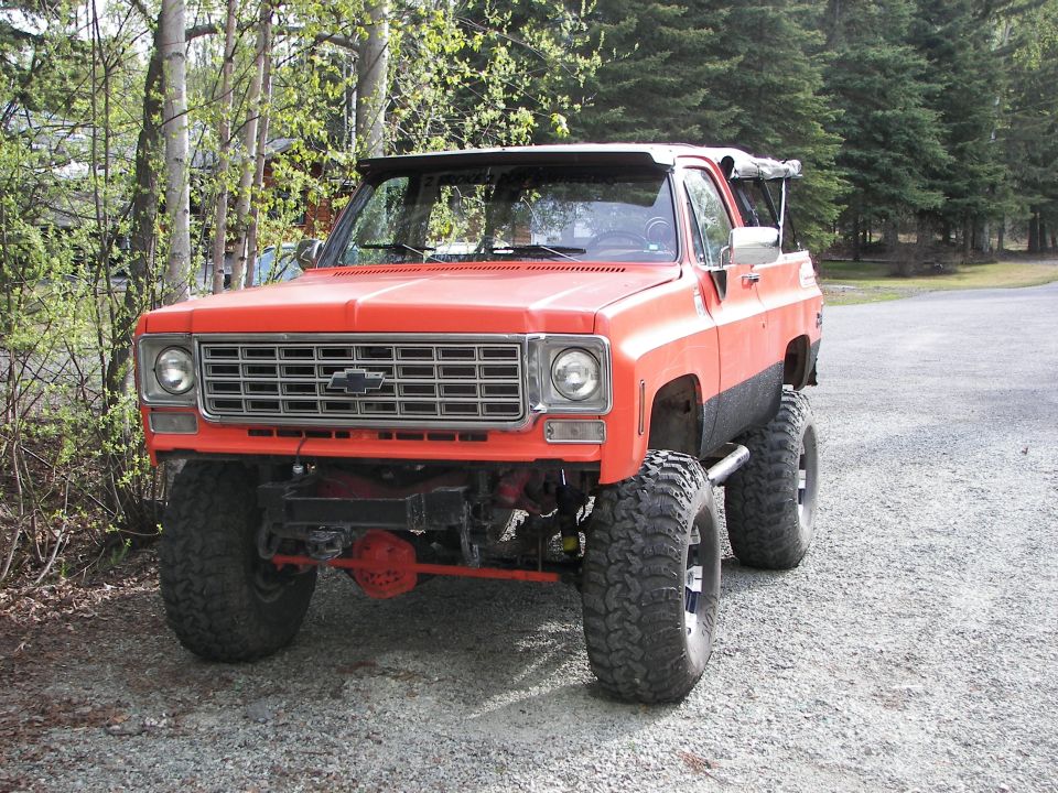 Orange lifted SUV with a prominent grille and large tires