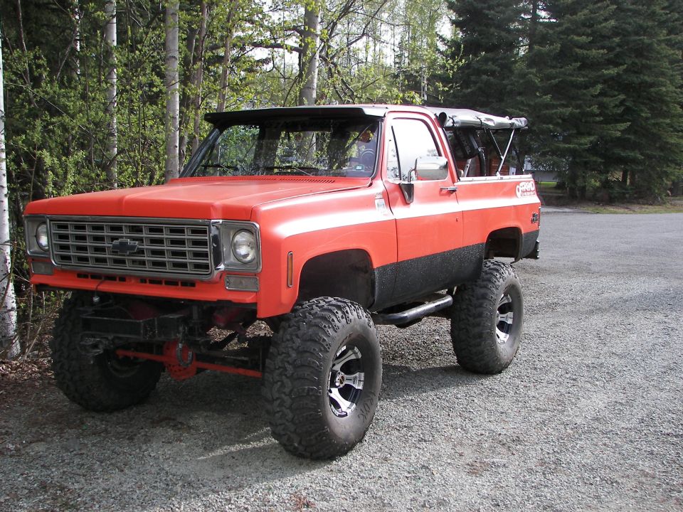 Lifted orange 1975 Chevrolet K5 Blazer with black trim and large off-road tires