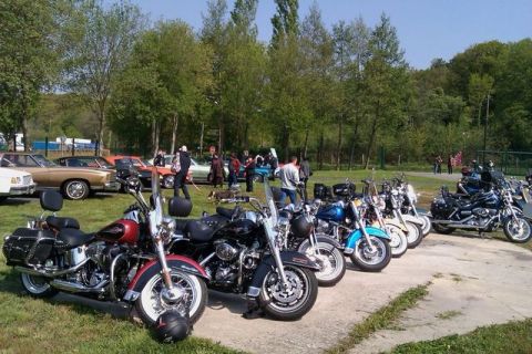 1991 Ford LTD Crown Victoria - A row of motorcycles are parked outside on a sunny day with cars and people in the background.