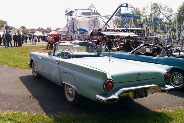 Light blue 1957 Ford Thunderbird convertible, rear view, parked next to another convertible