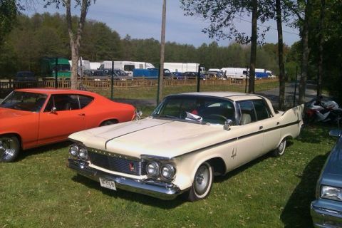 1991 Ford LTD Crown Victoria - A classic 1960 Chrysler Imperial is parked on a grassy field with other vehicles in the background.