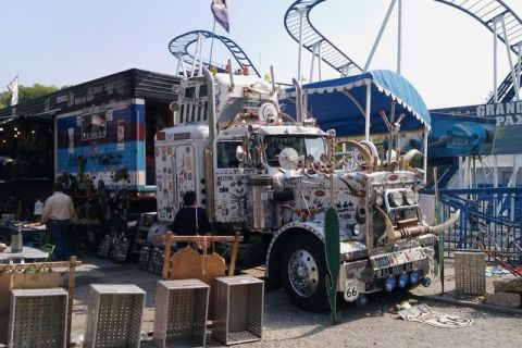 1991 Ford LTD Crown Victoria - This heavily decorated semi-truck features steer horns and numerous decals, parked near a roller coaster.