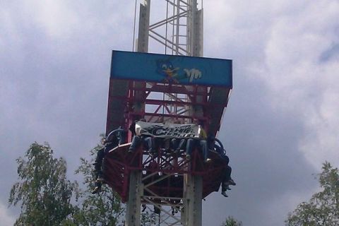 1991 Ford LTD Crown Victoria - People ride a drop tower amusement ride, holding a banner that says 'Happy Days Musicbox'.