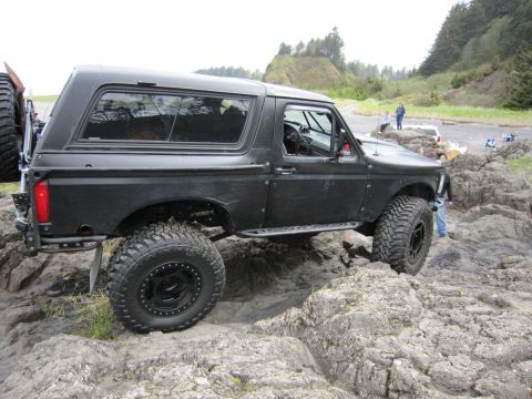 1996 Ford Bronco - 1996 Ford Bronco navigating rocky terrain on a coastal path.