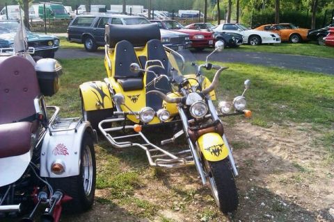 1991 Ford LTD Crown Victoria - A custom yellow trike motorcycle with a unique design is parked outdoors with other vehicles in the background.