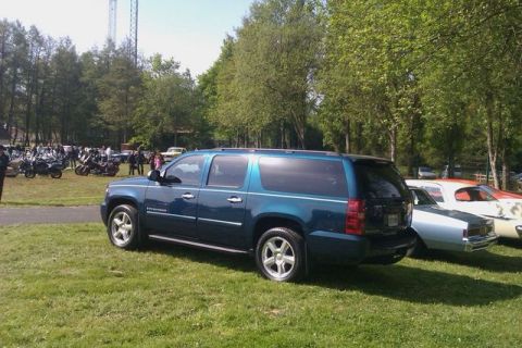 1991 Ford LTD Crown Victoria - Blue SUV parked on grass with other vehicles and motorcycles in the background.
