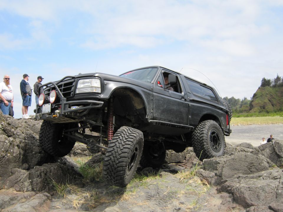 Black Ford Bronco with off-road modifications navigating rocky terrain