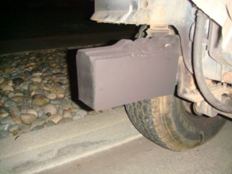 1994 Ford Bronco - A custom bumper extension is attached to the vehicle's frame, partially obscuring the tire and surrounding gravel.