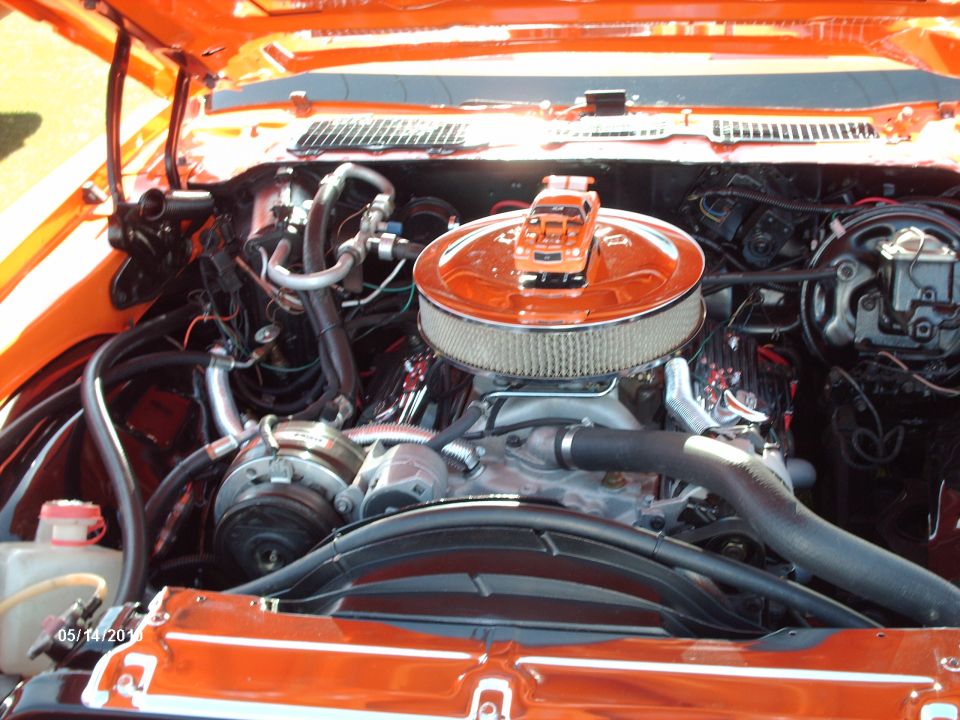 Orange engine bay with a toy truck on the air cleaner
