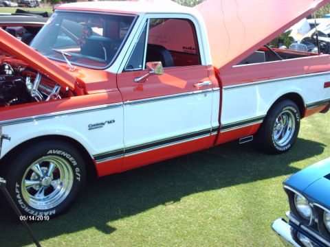 1992 Ford Bronco - A two-tone red and white Chevrolet C10 pickup truck is displayed with its hood and tailgate open at a car show.
