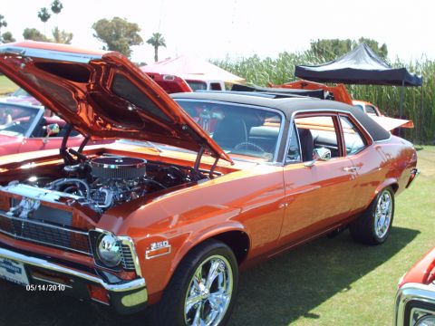 1992 Ford Bronco - This orange 1970 Chevrolet Nova is displayed with its hood open at an outdoor car show.
